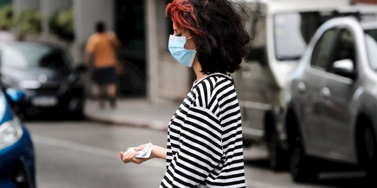 Mujer caminando por la calle con tapabocas