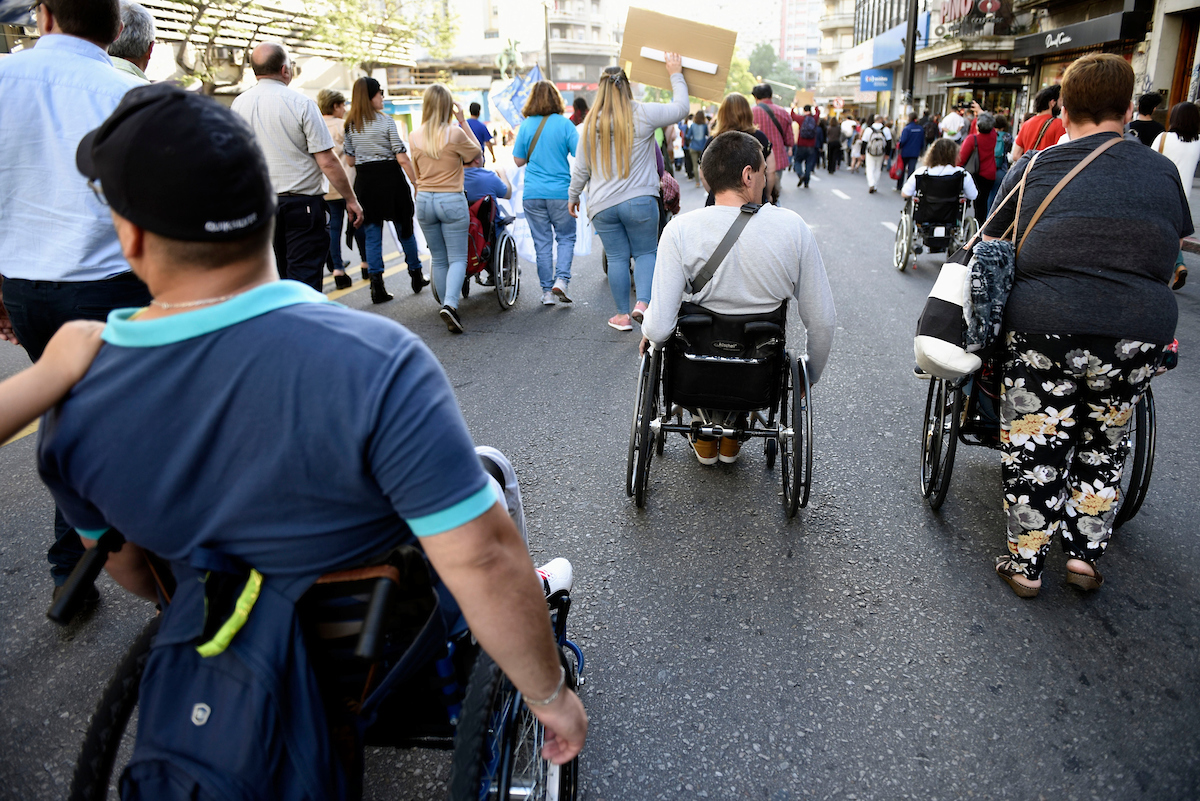 Personas discapacitadas caminando en silla de ruedas en una marcha