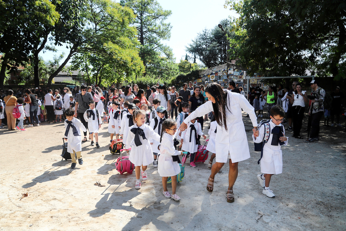 Maestra dirigiendo a sus alumnos por el patio de una escuela