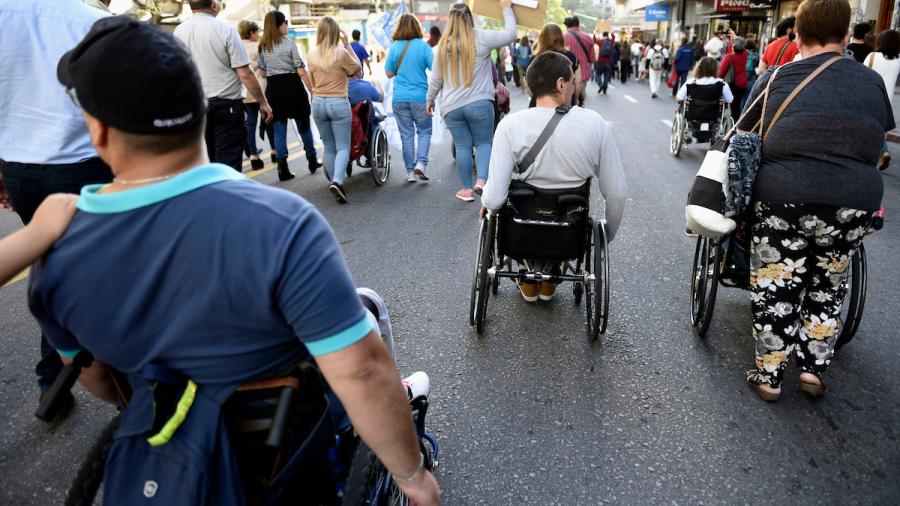 Personas discapacitadas caminando en silla de ruedas en una marcha